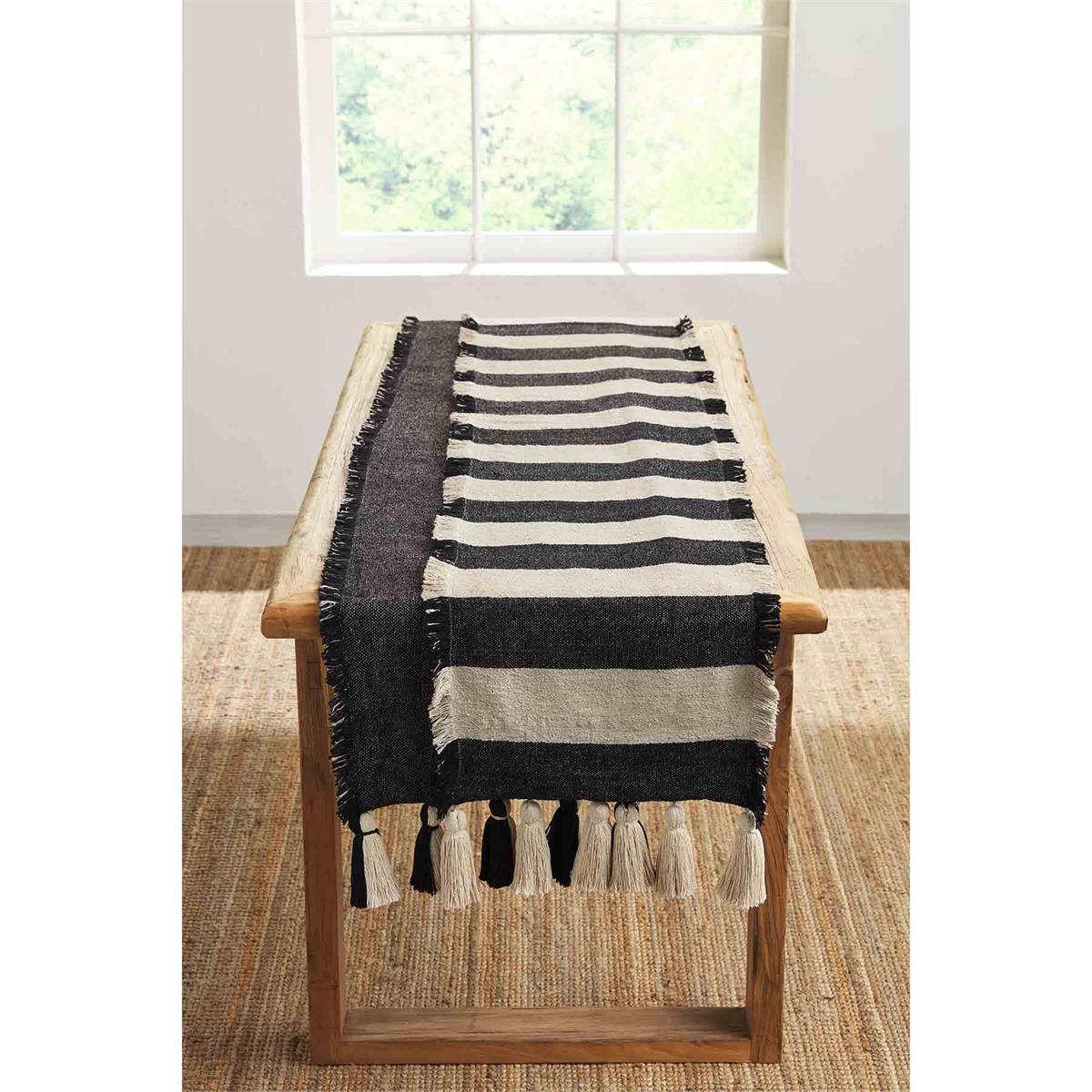 Ponchaa cotton table runner features chunky tassel hem.